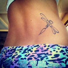 a woman with a tattoo on her back that has a dragonfly drawn on it