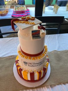 a three tiered cake is decorated with gold, white and red decorations on top