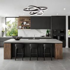 a modern kitchen with black cabinets and marble counter tops, an island bar area and three stools