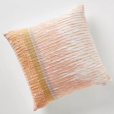 an orange and white striped pillow sitting on top of a table