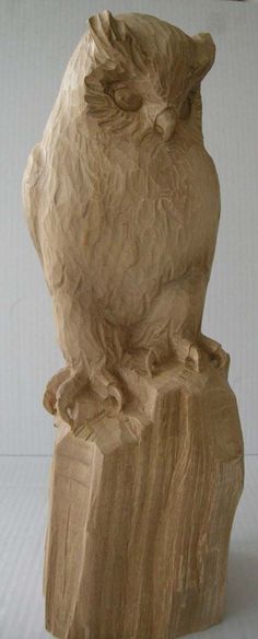 an owl statue sitting on top of a wooden block