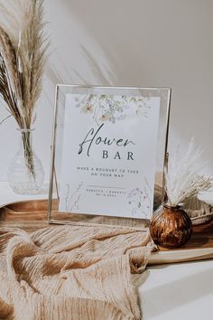 there is a sign that says flower bar next to some dried flowers and a vase