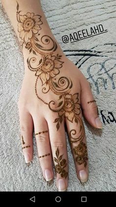 a woman's hand with henna tattoos on it