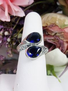 Simulated Sapphire Ring Description Swirl Snake Design#221 MADE TO ORDER This gorgeous ring is a Vintage/Retro inspiration in solid sterling silver. The lovely ring is set with 2 man-made/simulated sapphire gemstones, approximately 2.5ct each, 5ctw. The teardrop cut sapphire blue gem are an eye-catching unique design. The inside of the band is marked 925 for sterling. Notice the beautiful unique design of the silver filigree setting. This ring is fun and very comfortable to wear. This ring reall Teardrop Sapphire Ring In Sterling Silver For Anniversary, Sterling Silver Teardrop Sapphire Ring For Anniversary, Sapphire Teardrop Sterling Silver Ring, Blue Sterling Silver Teardrop Ring, Sterling Silver Teardrop Blue Ring, Blue Teardrop Sterling Silver Ring, Ring Teardrop, Retro Inspiration, Blue Sapphire Ring