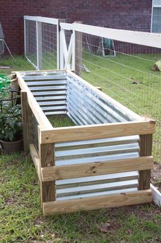 a garden bed made out of wooden pallets in the grass next to a fence