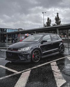 a black car is parked in the rain