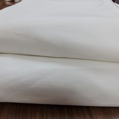 two white pillows sitting next to each other on a wooden floor