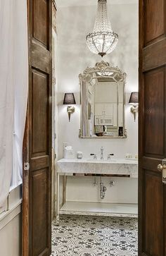 an open door leading to a bathroom with a chandelier