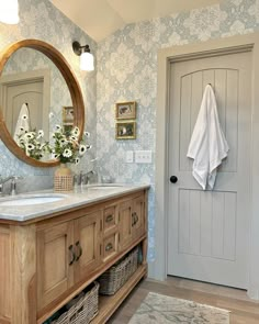 a bathroom with blue wallpaper and wooden cabinets