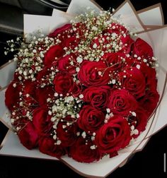 a bouquet of red roses and baby's breath