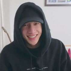 a young man wearing a black hoodie and smiling