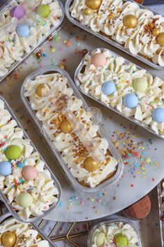 there are many desserts in plastic trays on the table with sprinkles