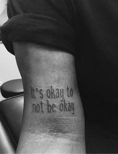 a person with a tattoo that says it's okay to not be okay