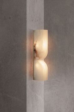 a wall light that is on the side of a concrete wall with a white background