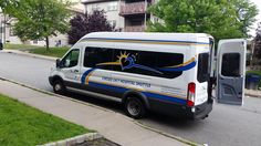 a white and blue van parked on the side of a road next to a building