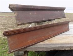 two pieces of wood sitting on top of a wooden table in the middle of a field