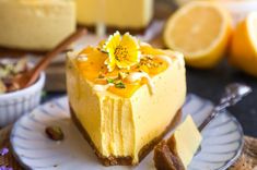 a piece of cheesecake on a plate with lemons and flowers in the background