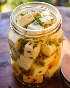 a jar filled with diced food sitting on top of a wooden table