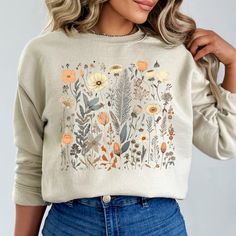 This minimalist, unisex heavy blend crewneck Wildflowers Ladies Sweatshirt is pure comfort. These cute Ladies Sweaters are made from polyester and cotton. This combination helps designs come out looking fresh and beautiful. The collar is ribbed knit, so it retains its shape even after washing. There are no itchy side seams on these sweaters.  .: 50% cotton, 50% polyester .: Medium-heavy fabric (8.0 oz/yd² (271.25 g/m .: Loose fit .: Sewn-in label .: Runs true to size Spring Floral Embroidered Crew Neck Sweatshirt, Spring Long Sleeve Botanical Sweatshirt, Wildflower Sweatshirt, Floral Print Crew Neck T-shirt For Mother's Day, Spring Botanical Flower T-shirt, Floral Sweater, Flower Shirt, Cute Sweaters, Cute Woman