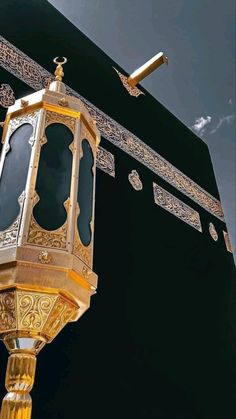 an ornate gold and black lantern on top of a building