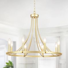 a gold chandelier with five lights hanging from the ceiling in a dining room