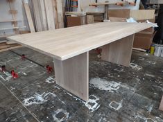 a large wooden table sitting on top of a floor next to other woodworking tools