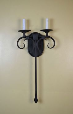 a wall mounted candle holder with two candles