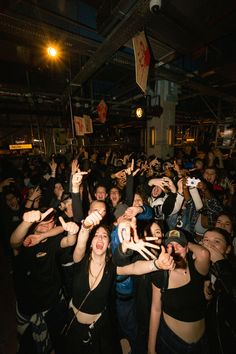 a group of people standing around each other with their hands in the air