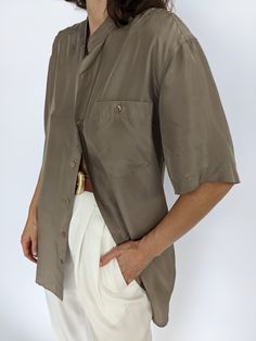 Beautiful latte toned silk top - this blouse has a collarless neckline and iridescent matching buttons down the front & a single breast pocket. Tag reads Personal Choice Faint discolorations at the sleeves and at front with very subtle discolorations under arms. Formal Short Sleeve Tops With Pockets, Vintage Silk Blouse, Silk Shirt With Button Closure, Casual Silk Shirt With Buttons, Elegant Beige Top With Placket Detail, Elegant Beige Tops With Placket, Elegant Brown Tops For Daywear, Silk Tops For Semi-formal Summer Occasions, Casual Silk Blouse With Buttons