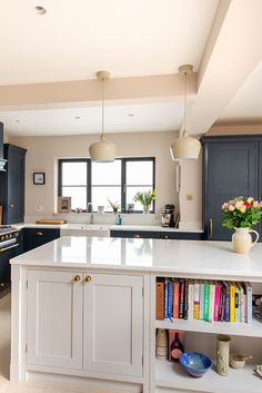 a kitchen with blue cabinets and an island in the middle is seen from across the room