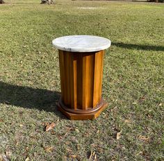 a marble topped table in the middle of a grassy field