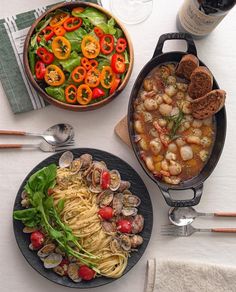 two plates of food on a table with utensils