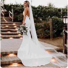 a woman in a wedding dress standing on some steps