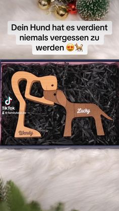 a wooden toy dog in a box with christmas decorations around it and the caption that reads, diein hund hat es verdient niernn nenals vergen ergesen zu