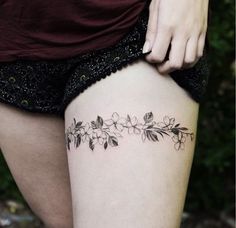 a close up of a person's thigh with flowers on it and the bottom half of her leg