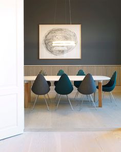 a dining room table with chairs and a painting on the wall