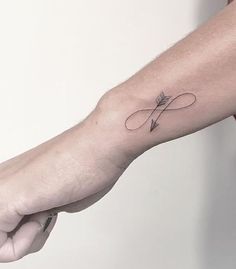 a person's arm with an arrow tattoo on the left side of their arm