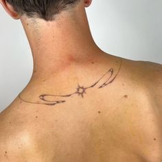 the back of a man's neck with an arrow and stars tattoo on it