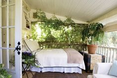 a bed sitting on top of a wooden floor next to a white chair and window