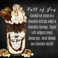 a chocolate milkshake with whipped cream and toppings in a jar on a chalkboard background