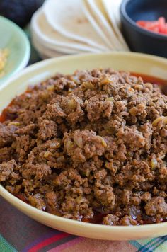 a close up of a bowl of food on a table with other dishes in the background