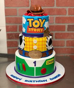 a toy story birthday cake on a table with a brick wall in the back ground