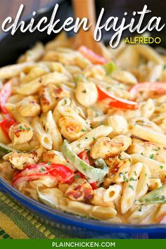 a blue bowl filled with pasta and vegetables