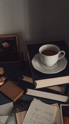 a stack of books and a cup of tea on top of each other next to an open book