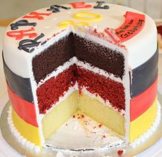 a multi - colored birthday cake with one slice cut out