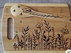 a wooden cutting board with flowers and butterflies on it