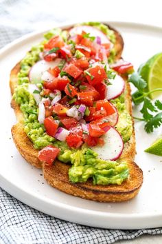 an open face sandwich with avocado, tomatoes and cilantro on it