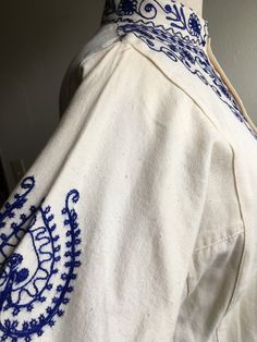 "1970s handmade embroidered tunic dress shirt cream with dark blue 3 button up neck side panels side slits (4 1/2\") nubby cotton w/light flecks light wear, good condition irregularities to fabric normal to artisan textiles no tags measures, flat, shoulder-14\" chest-20 sleeve-17 length-32" Summer Cotton Kurta With Embroidered Sleeves, Bohemian Summer Kurta With Embroidered Sleeves, Summer Bohemian Kurta With Embroidered Sleeves, Traditional Button-up Cotton Blouse, Spring Folk Style Cotton Kurta, Folk Style Cotton Kurta For Spring, Cotton Folk Style Kurta For Spring, Bohemian Embroidered Cream Kurta, Cream Bohemian Cotton Kurta