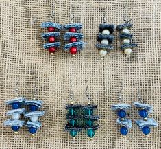 four pieces of beaded jewelry laid out on a piece of burlied fabric