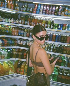 a woman wearing a fake mask and looking at her cell phone in a grocery store